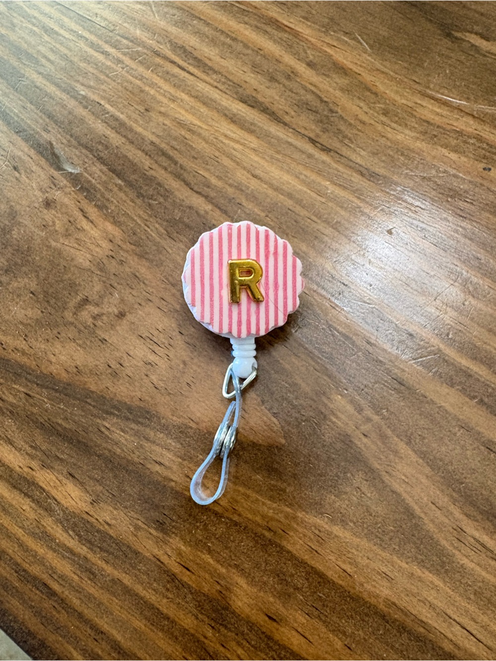 Pink badge reel with gold R